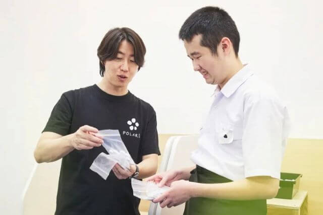 印刷物を確認する二人の男性